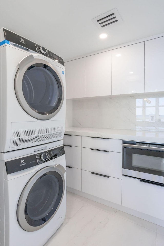 laundry area featuring stacked washer / drying machine