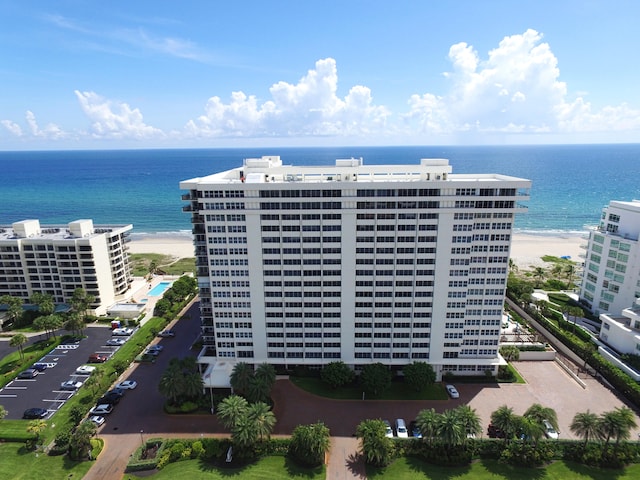 drone / aerial view featuring a water view and a view of the beach