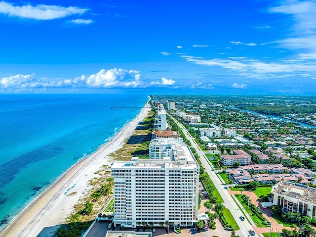 birds eye view of property featuring a water view and a beach view