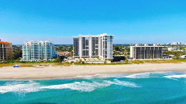 bird's eye view featuring a water view and a beach view