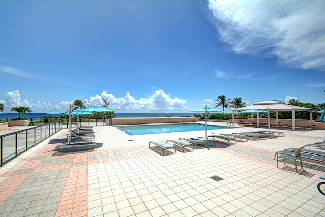 view of swimming pool featuring a water view, a patio, and a gazebo