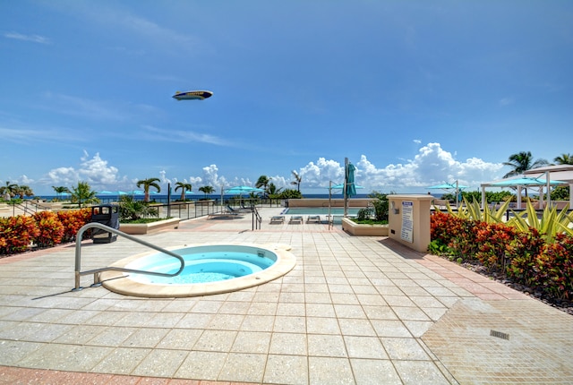 view of swimming pool featuring a hot tub and a patio