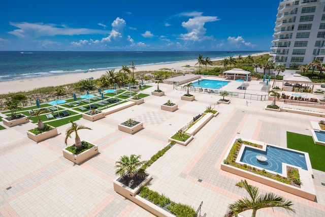 bird's eye view featuring a water view and a beach view