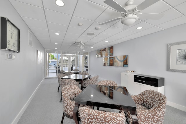 carpeted dining area with a drop ceiling and ceiling fan