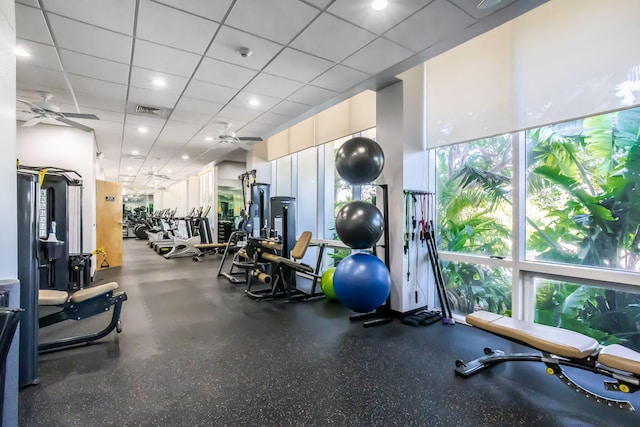 exercise room with a drop ceiling and ceiling fan