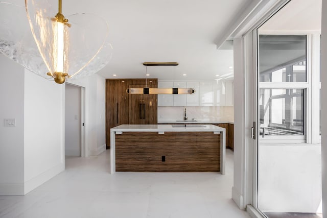 kitchen with white cabinetry, backsplash, wood walls, and sink