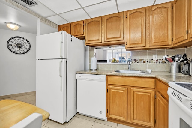 kitchen with light tile patterned flooring, sink, tasteful backsplash, a drop ceiling, and white appliances