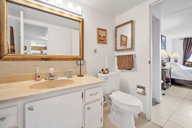 bathroom featuring toilet, vanity, a textured ceiling, and tile patterned flooring