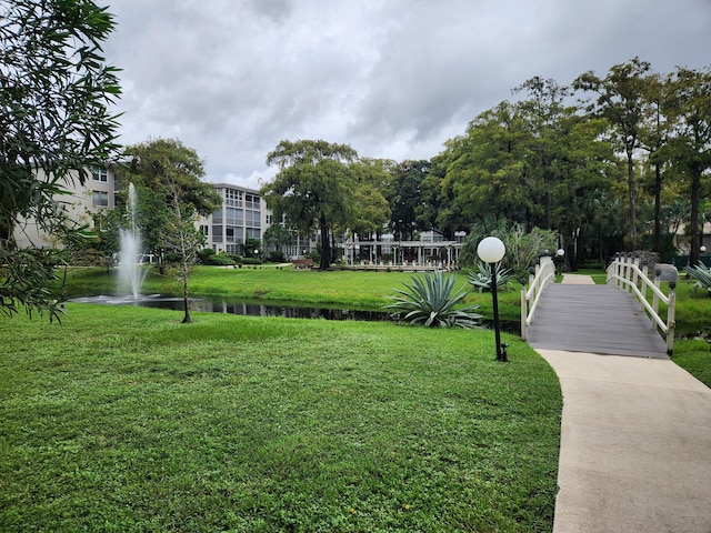 surrounding community featuring a water view and a lawn