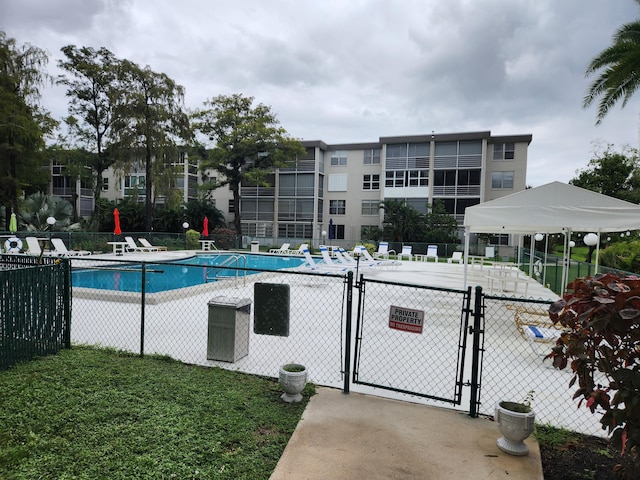 view of pool featuring a lawn