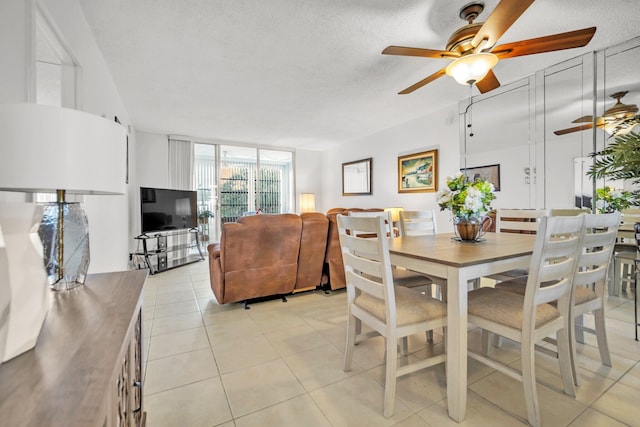 dining space featuring a textured ceiling, ceiling fan, and light tile patterned floors