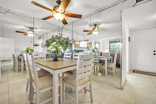 tiled dining room featuring ceiling fan and a textured ceiling