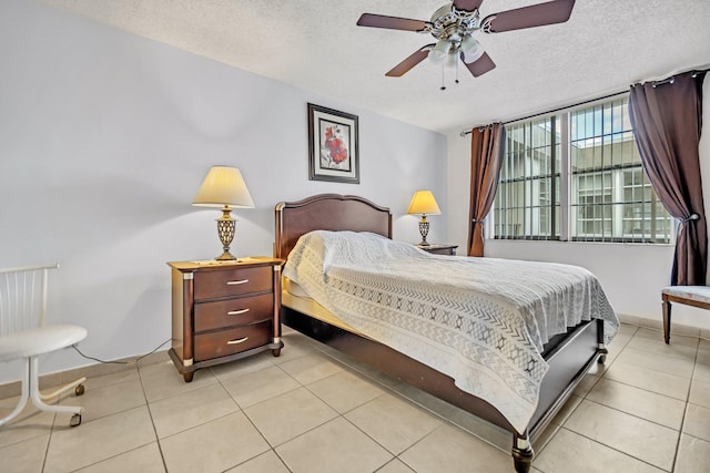 bedroom with a textured ceiling, light tile patterned floors, and ceiling fan