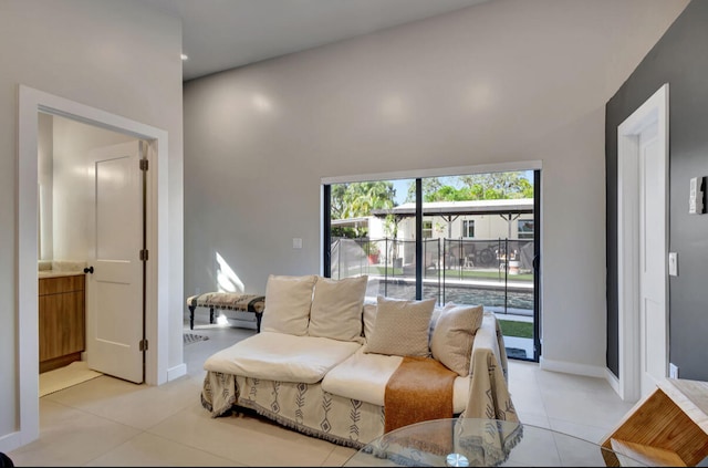 living room with a towering ceiling and light tile patterned flooring