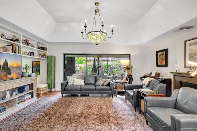 living room with hardwood / wood-style floors, a raised ceiling, a textured ceiling, and a chandelier