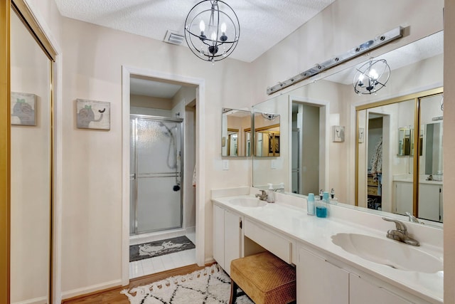 bathroom featuring an enclosed shower, wood-type flooring, and a textured ceiling