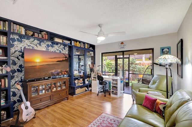 living room featuring ceiling fan, hardwood / wood-style floors, and a textured ceiling