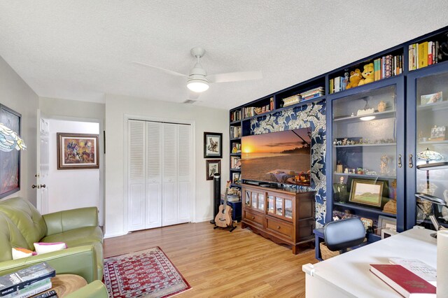 interior space featuring a textured ceiling, hardwood / wood-style flooring, and ceiling fan