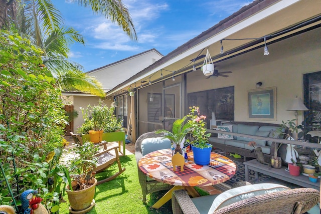 view of patio with ceiling fan and a sunroom