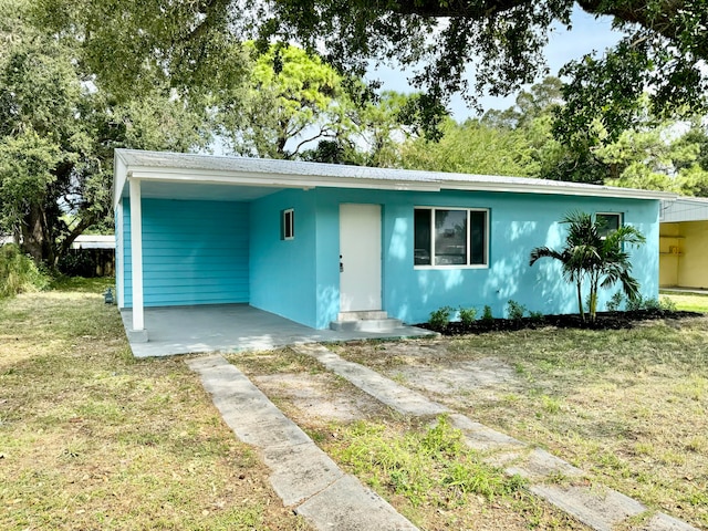 view of front of house with a carport and a front lawn