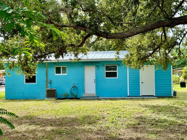 view of front facade featuring a front lawn and central AC unit