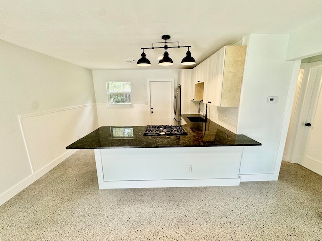 kitchen featuring kitchen peninsula, sink, hanging light fixtures, and stainless steel appliances