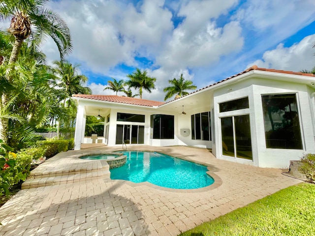 back of house featuring a swimming pool with hot tub, a patio, and ceiling fan