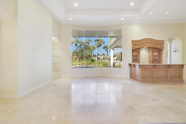 unfurnished living room with a raised ceiling, built in features, and crown molding