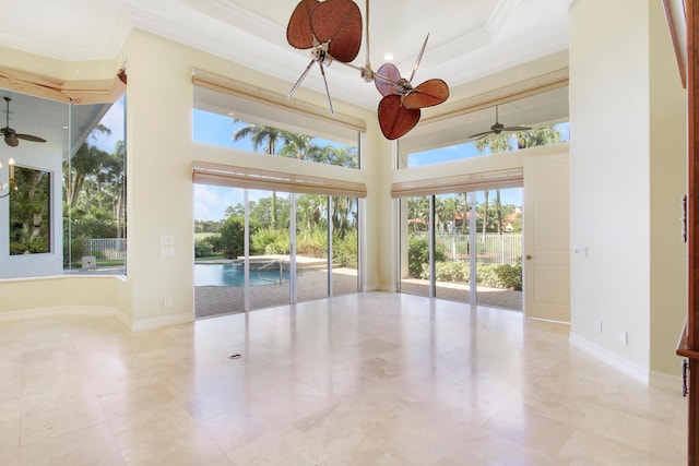 interior space featuring ceiling fan, plenty of natural light, and ornamental molding