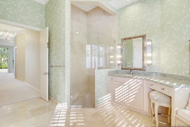 bathroom featuring a chandelier, vanity, and a shower with door