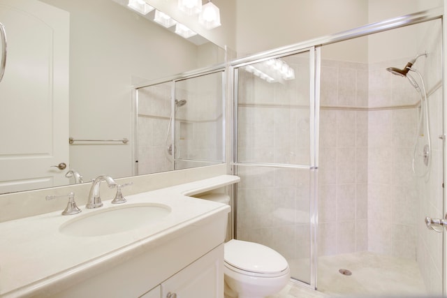 bathroom featuring vanity, toilet, and a shower with door