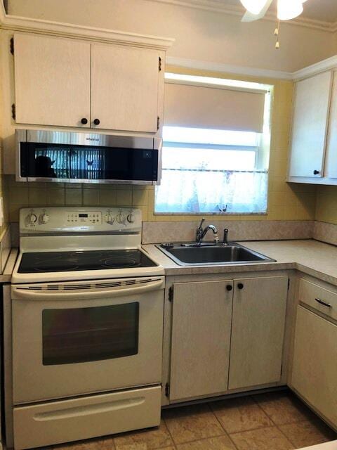 kitchen with light tile patterned floors, backsplash, white electric stove, crown molding, and sink