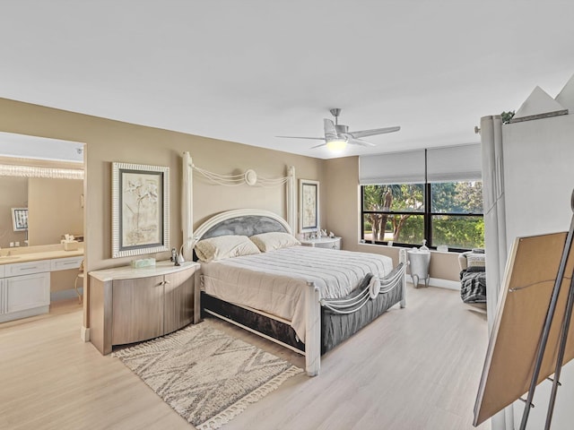 bedroom with ceiling fan, connected bathroom, and light hardwood / wood-style flooring