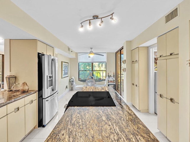 kitchen with stainless steel fridge with ice dispenser, cream cabinets, ceiling fan, and black electric stovetop