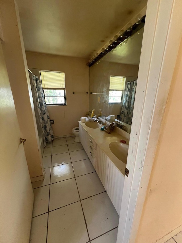 bathroom featuring toilet, plenty of natural light, vanity, and tile patterned floors