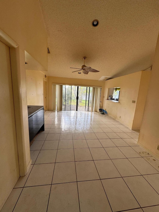 tiled empty room with a textured ceiling and ceiling fan