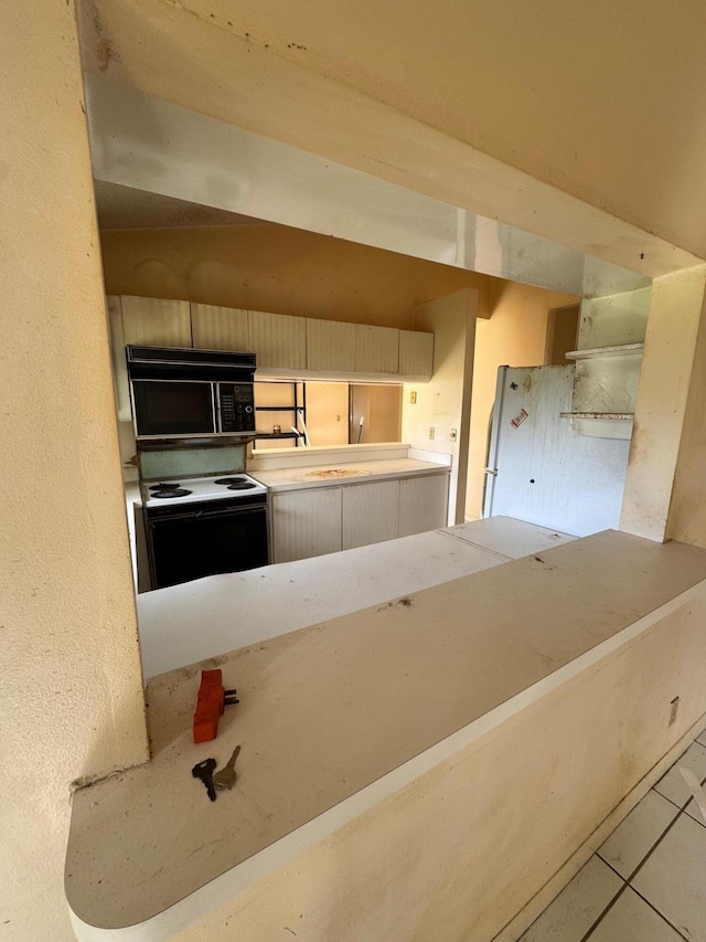 kitchen with tile patterned floors and white electric range oven