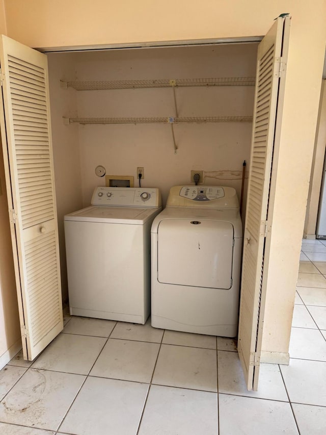 laundry area with light tile patterned floors and washer and dryer