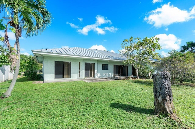 back of house with a patio area and a lawn