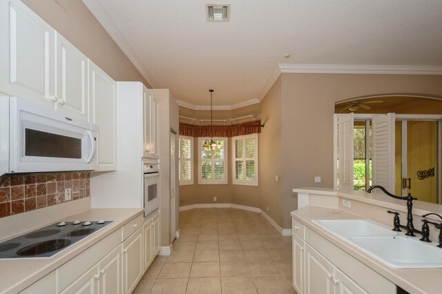 kitchen with white cabinetry, a healthy amount of sunlight, and white appliances