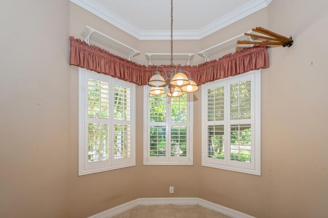 spare room with ornamental molding, an inviting chandelier, and tile patterned floors