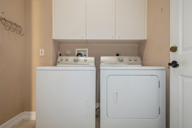 washroom featuring cabinets and washer and clothes dryer