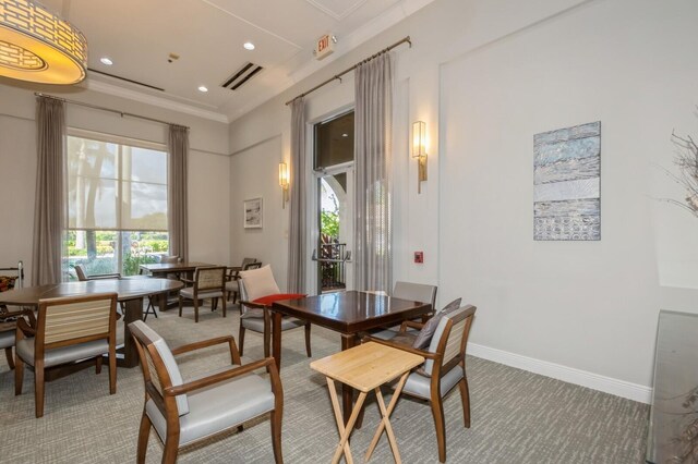 carpeted dining area with ornamental molding