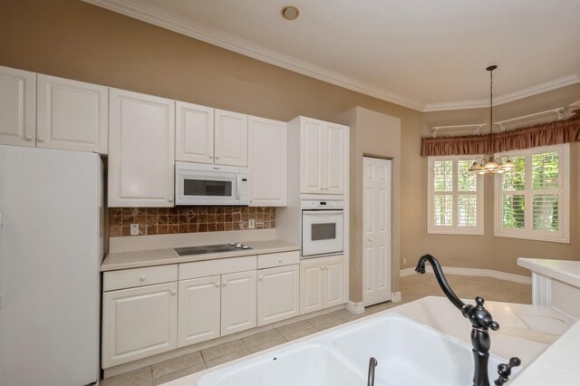 kitchen featuring white appliances, decorative light fixtures, white cabinets, crown molding, and a notable chandelier