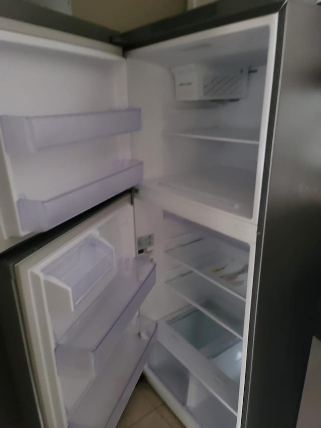 interior space featuring white fridge and tile patterned flooring