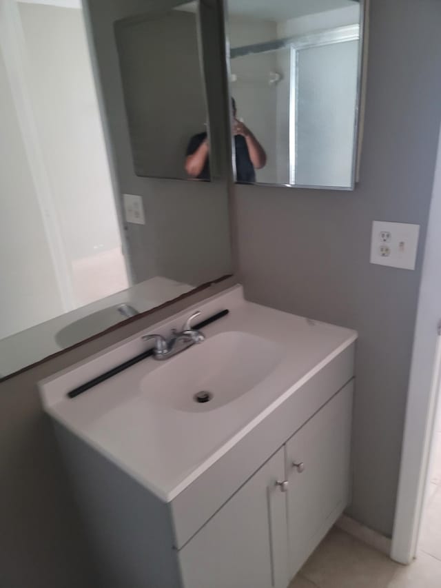 bathroom featuring vanity, walk in shower, and tile patterned floors