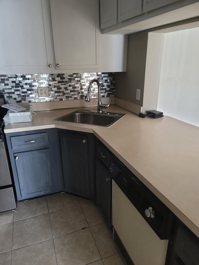 kitchen with decorative backsplash, gray cabinetry, dishwashing machine, sink, and light tile patterned floors