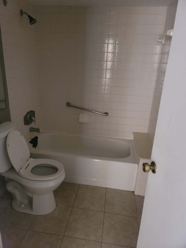 bathroom with toilet, tile patterned floors, and tiled shower / bath combo