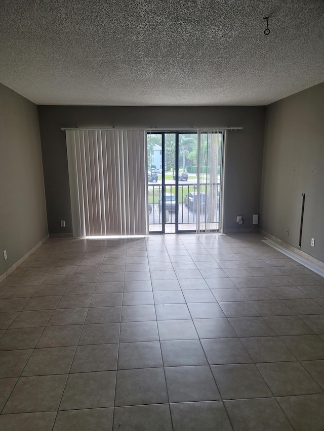 unfurnished room featuring a textured ceiling and tile patterned flooring