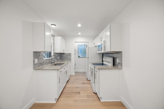 kitchen featuring white appliances, sink, decorative backsplash, light stone counters, and white cabinetry